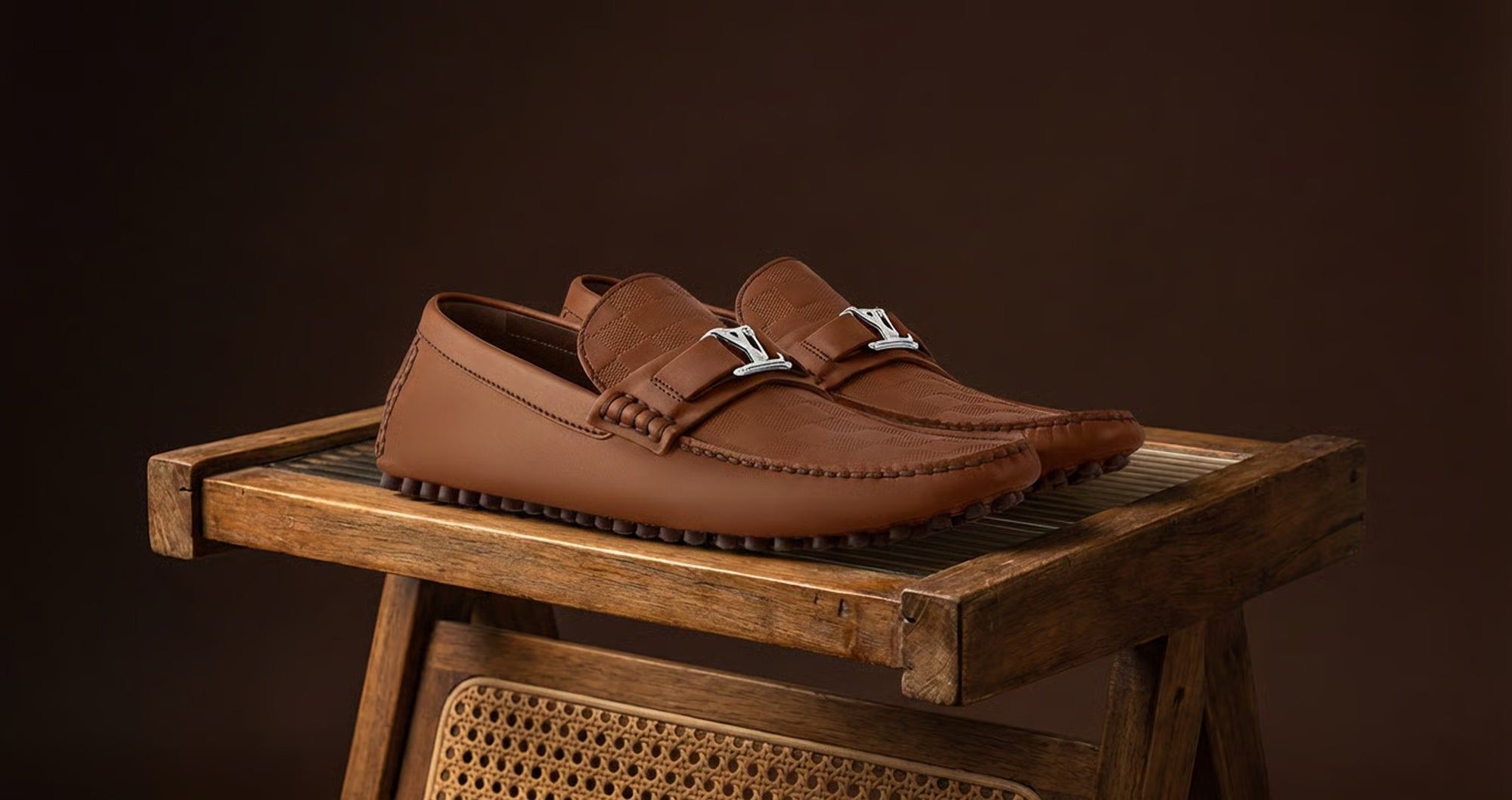Brown Louis Vuitton loafers on a wooden stool